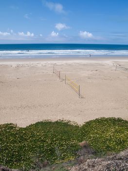 beach volleyball net with ocean in background