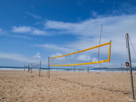 beach volleyball net with ocean in background