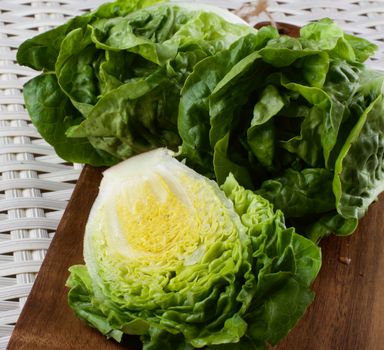 Fresh Crunchy Romaine Lettuce Half and Full Heads closeup on Wooden Cutting Board 