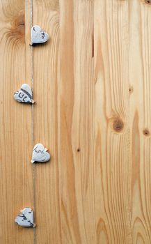 Four hearts with clothes pegs on a cord on wood