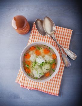 Chicken soup with meatballs and vegetables with a napkin