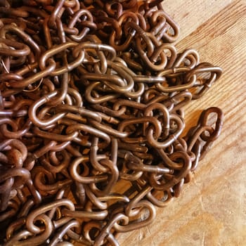 Rusty metal chains on wooden background. Retro style image.