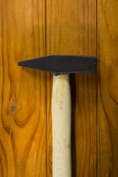 Hammer for hammering nails on the wooden background