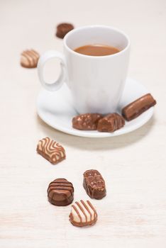 Glass of chocolate milk and variety chocolates  on table