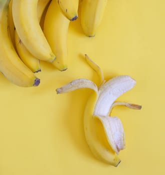 Ripe bananas set on yellow background