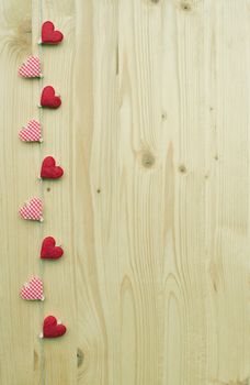 Nine hearts with clothes pegs on a cord on wood