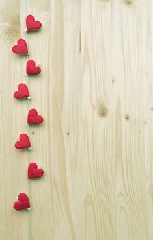 Eight hearts with clothes pegs on a cord on wood