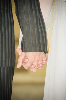 Young married couple holding hands ceremony wedding day