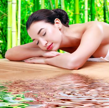 Young beautiful asian woman relaxing at spa salon in bamboo forest