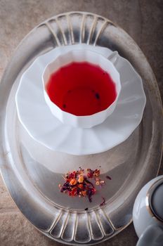 A cup of Red fruit tea with a kettle