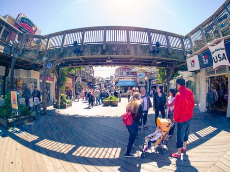 San Francisco, CA, USA - April 3, 2017: Touring family with child in carriage standing under the wooden bridge at Pier 39, Fisherman's Wharf