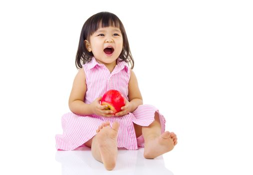 Cute asian girl sitting on the floor and holding an apple