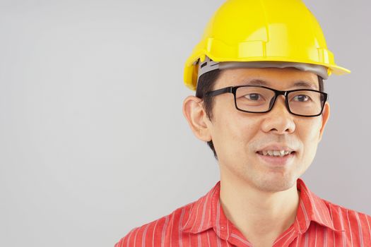 Engineer wear red shirt and yellow engineer hat with black spectacles look to the front on white background.