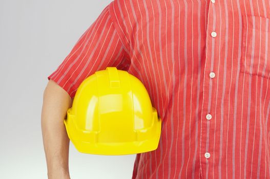Engineer with red shirt hold yellow engineer hat on white background.