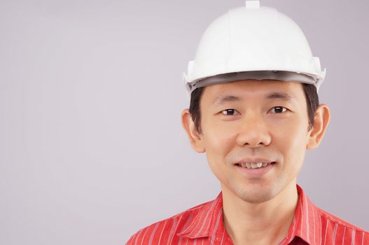 Happy engineer wear red shirt and white engineer hat look to the front on white background.