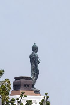The old buddha statue stand on lotus in Thailand.