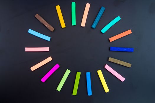 circle of colorful chalk on blackboard background
