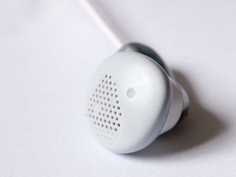 close up of a single ear bud headphone white