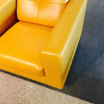 Bright yellow leather armchair. Stylish modern furniture.