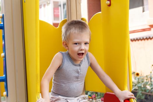 Portrait of cute blond boy with open mouth