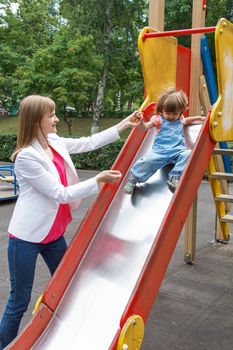 Mother with baby girl riding on hutches with screw up one eyes