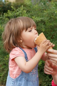 Vertical photo of cute girl are eating icecream in summer time