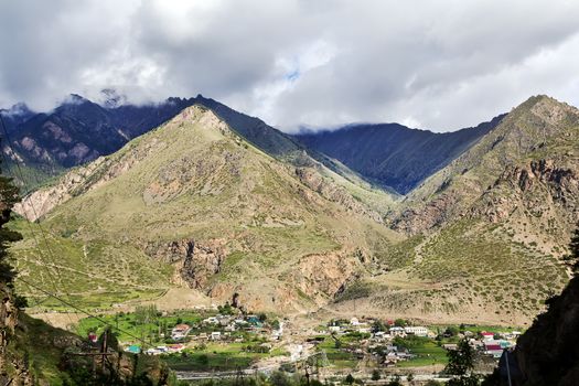 Picturesque landscape with a small village at the foot of mountains