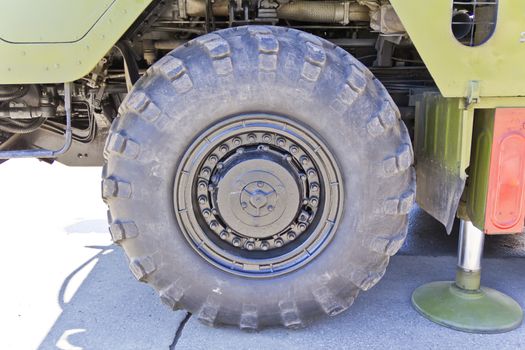 Wheel of military machine at the exhibition under open sky