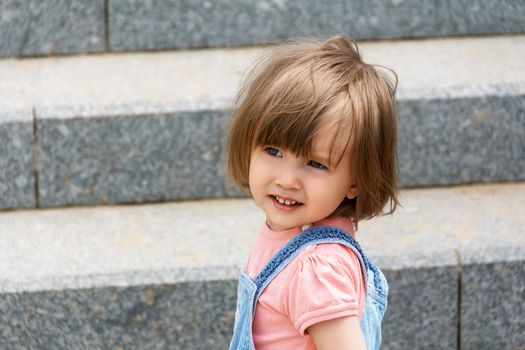 Portrait of baby girl on the stairs background