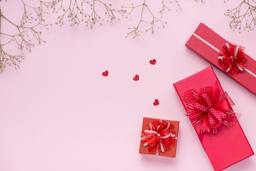 Red gift boxes tied with ribbon and white flowers for mothers day