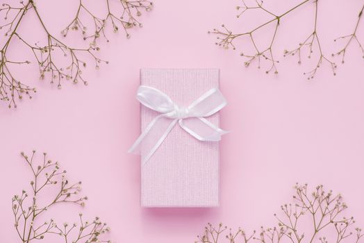 Gift box tied with pink ribbon and white flowers for mothers day