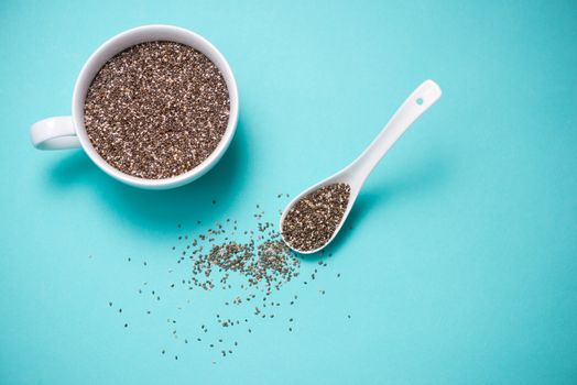 Cup of healthy chia seeds and spoon. Text space.