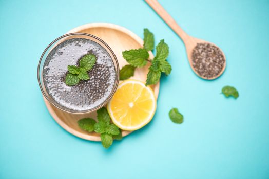 Selective focus of chia seeds drink with water in transparent glass with lemon balm. 