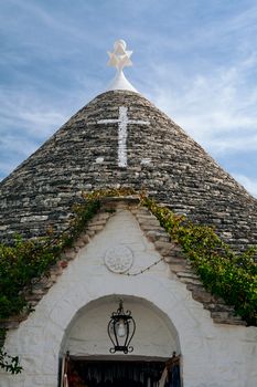 Symbol in the Trullo conical rooftop in Alberobello under a blue sky, Puglia, Italy