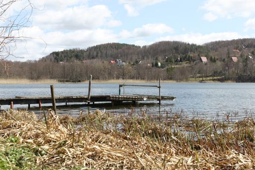 Old, worn out platform on the lake. 
Around the mountainous area and forest.