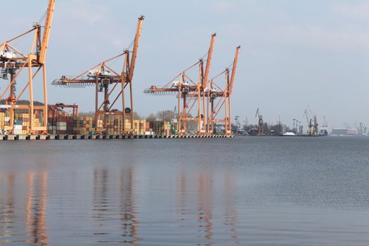 Cranes and containers against the sky and the Baltic sea. Gdynia, Poland