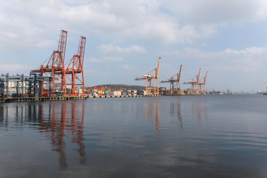 Cranes and containers against the sky and the Baltic sea. Gdynia, Poland