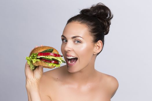 Young woman eating hamburger made of vegetables, healthy eating concept