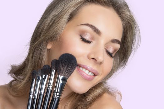 Portrait of beauty girl with makeup brushes set
