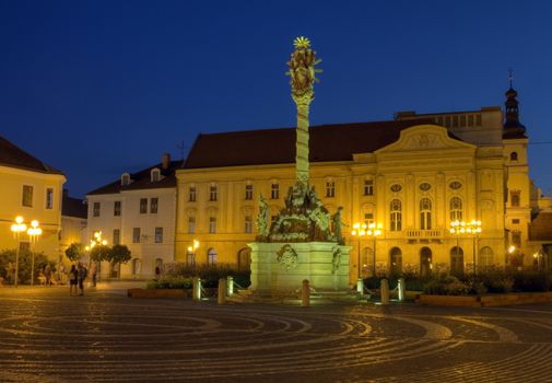 Plague column on Holy Trinity square by night in Trnava, Slovakia