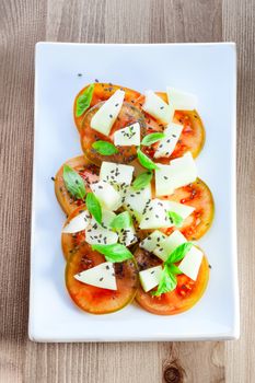 Tomato salad with melon, cheese, basil sesame