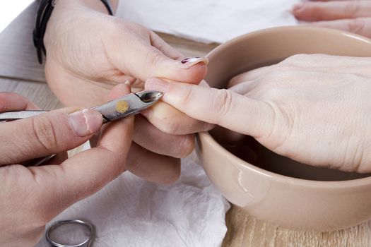 Professional manicure procedure in beauty salon. Hands close up.