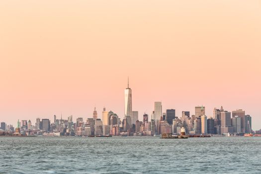 New York City Manhattan downtown skyline at dusk with skyscrapers illuminated over Hudson River panorama. Horizontal composition, copy space.