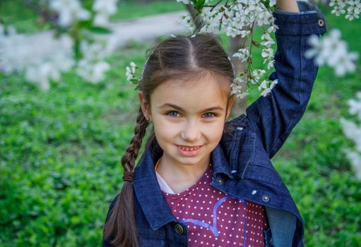 Happy girl closeup portrait among spring garden