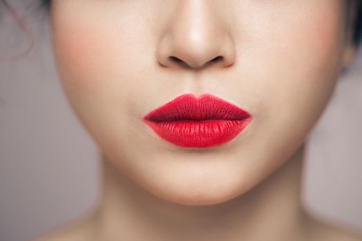Close up view of beautiful woman lips with red lipstick.