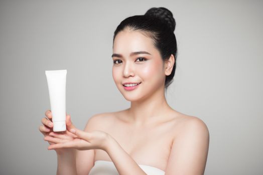 Beautiful asian Woman Face Portrait holding and presenting cream tube product