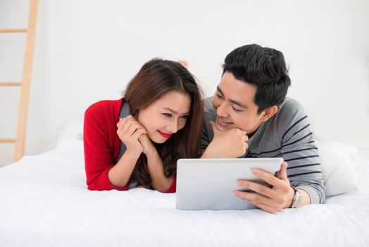 Asian couple using digital tablet at home