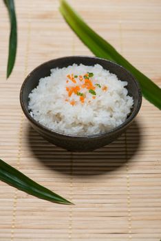 Boiled rice in a bowl on wooden table.