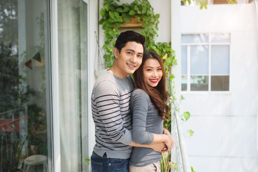 Couple in love sharing genuine emotions and happiness, hugging on the balcony