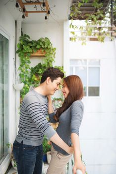 Couple in love sharing genuine emotions and happiness, hugging on the balcony